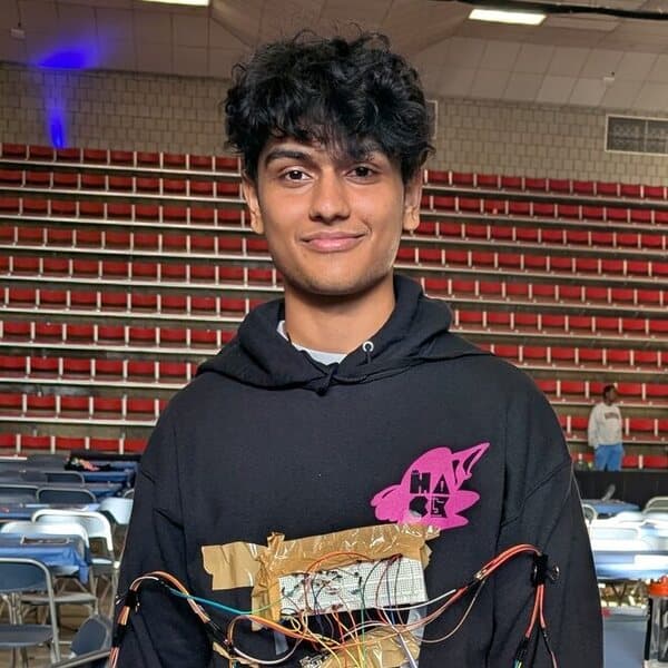 Sakshyam Sigdel wearing a sensor-wired hoodie at a hackathon